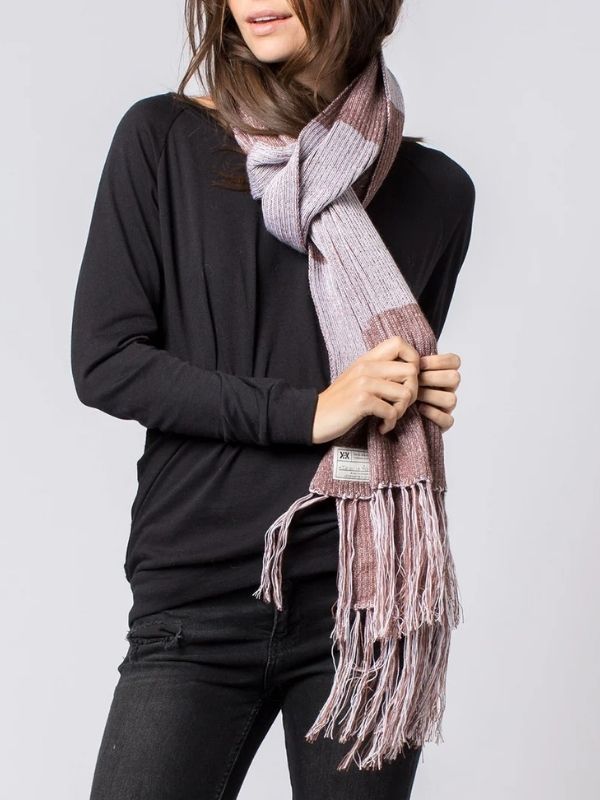 Woman wearing a pink and cream hand-crocheted scarf made from GOTS-certified organic cotton by Krochet Kids, styled with a black top and jeans